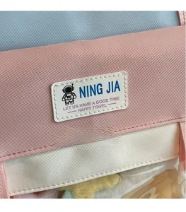 Dettaglio ravvicinato della borsa da viaggio in tela rosa e bianca con trama e logo
