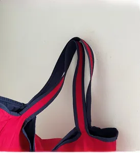 Detail of reinforced handles and stitching on this contrast color nylon tote bag
