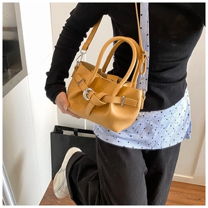Détail du sac seau plissé jaune moutarde avec boucle métallique et bandoulière amovible