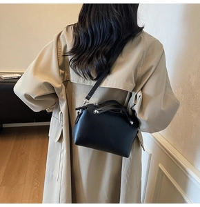 Detail einer schwarzen Mini-Boston-Tasche aus Leder mit Nieten und schmalem Schultergurt