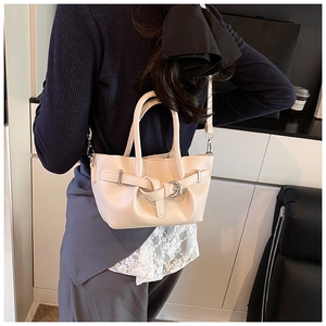 Détail du sac seau plissé crème avec boucle décorative présenté dans un décor de vie