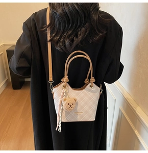 Vista posteriore di una modella che indossa la borsa a secchiello a quadri con ciondolo