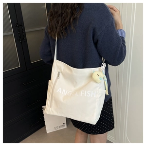 Detail of canvas shoulder bag showing Angel Fish print and cute plush fish charm
