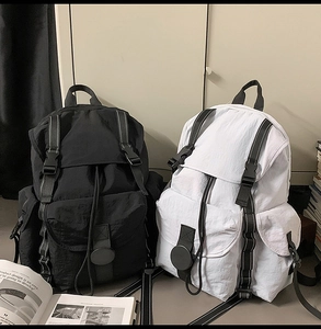 Detalle de mochila de nailon impermeable con cierre de hebilla y bolsillos múltiples