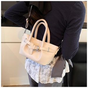 Détails d'un sac seau plissé beige avec boucle en métal argenté et poignées en cuir
