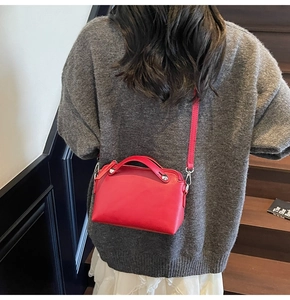 Detail der roten Ledertasche mit silbernem Metallbesatz und elegantem Tragegriff oben