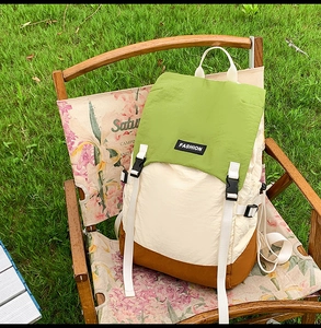 Detail of water-resistant tri-color outdoor backpack on a camping chair in nature
