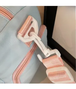 Dettaglio borsa da viaggio in nylon celeste con tracolla rosa e gancio in plastica