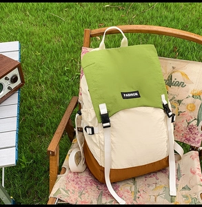 Detail of water-resistant tri-color outdoor backpack on a retro camping chair