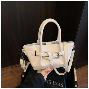 Détail d'un sac seau plissé blanc avec boucle métallique et bandoulière longue