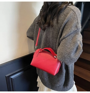 Details der roten Lederhandtasche mit silbernen Beschlägen und verstellbarem Schultergurt