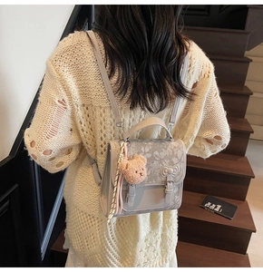 Detailed back view of a grey mini PU leather backpack with floral flap and bow detail