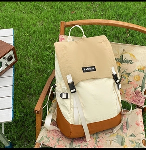 Detail of water-resistant hiking backpack with tricolor patchwork design and buckle closure