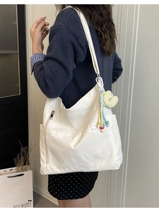 White hobo shoulder bag with Angel Fish print and yellow heart plush charm on a model