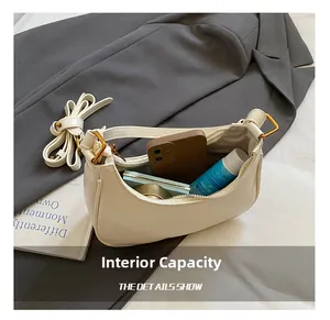 Detail view of the spacious internal capacity of this cream crescent shoulder bag