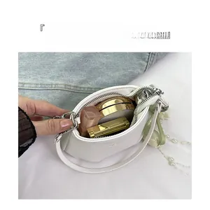 Détail de l'intérieur d'un sac en cuir blanc avec décorations de perles et foulard