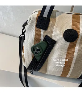 Front zipper pocket of a striped woven tote bag showing space for a smartphone
