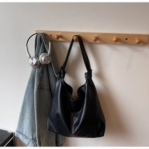 Détail du sac cabas en cuir noir avec bandoulière nouée décorative et grande capacité