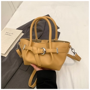 Détail du sac seau plissé jaune avec boucle décorative et bandoulière en métal
