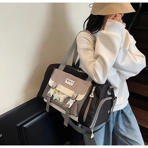 Dettaglio borsa da viaggio grande con tasche laterali, fibbia e tracolla regolabile