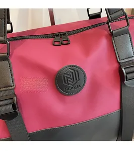 Detail of red travel bag featuring woven straps and premium double metal zippers