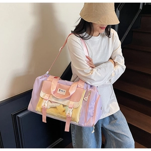 Dettaglio della borsa da viaggio colorata con tasca a fibbia e tracolla rosa regolabile