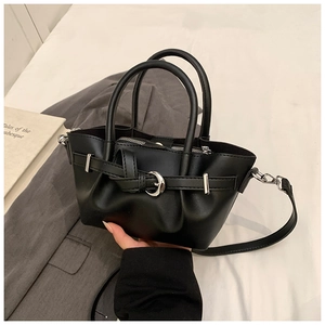 Détail du sac seau noir en similicuir avec boucle argentée et bandoulière amovible