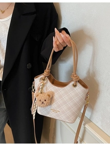 Elegante borsa a secchiello beige a scacchi con manici marroni e ciondolo a forma di orso