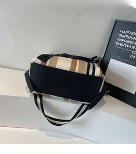 Detail shot of striped woven shoulder bag featuring durable black textured bottom base
