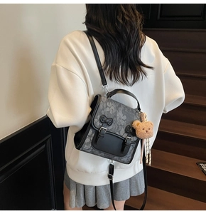 Detail of damask jacquard backpack with leather bow accent and bear plush charm