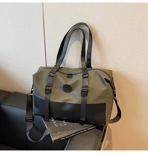 Detail view of olive green and black nylon travel bag featuring dual handles and shoulder strap