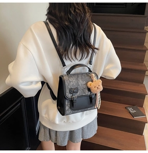 Detail of retro gray patterned backpack with black bow and cute brown bear plush charm
