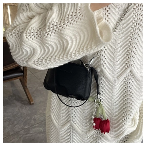 Détail du mini sac en cuir grainé noir avec chaîne argentée et breloque tulipe