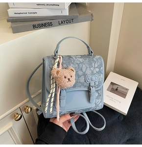 Detail of floral backpack with blue bow, PU leather flap and cute plush bear charm