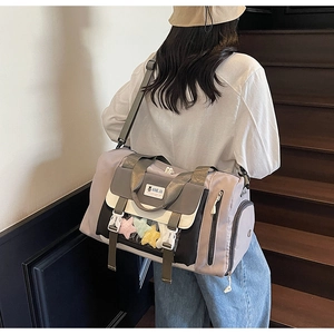 Dettaglio della borsa da viaggio viola con design color-block e tasche multifunzione