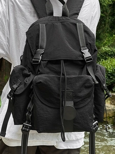 Mochila utilitaria negra impermeable con múltiples bolsillos mostrada en un modelo