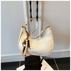 Detail of white leather crescent bag with wooden beads and fashion bags text logo