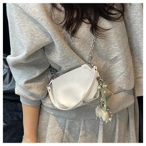 Détail du sac seau blanc en cuir avec chaîne argentée et breloques de perles et fleurs