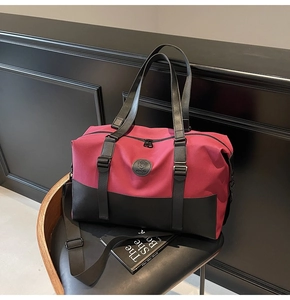 Detail of a large capacity travel bag featuring dark rose nylon and black leather accents
