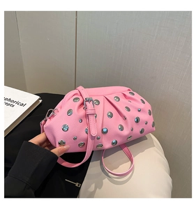 Dettaglio della borsa in pelle rosa martellata con borchie argentate e tracolla