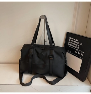 Close-up of black travel duffel bag with durable nylon texture and reinforced shoulder strap