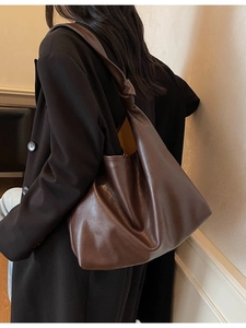 Deep brown leather tote bag with large capacity and stylish knotted shoulder strap details