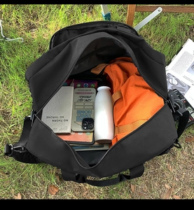 Top view of large black canvas travel bag showing spacious interior with laptop and gear