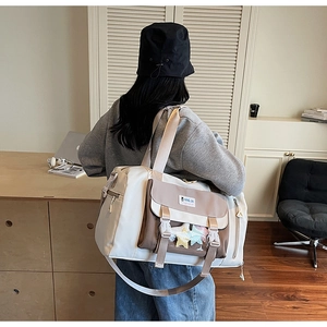 Dettaglio borsa da viaggio bicolore con tasca a stella e tracolla larga regolabile