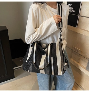 Detailed view of a striped canvas tote bag with wide textile strap for yoga and fitness