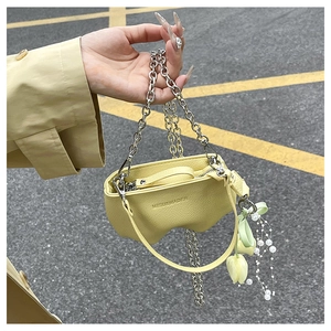 Gros plan du mini sac seau jaune vif avec chaîne argentée et breloque perle tulipe