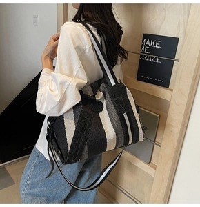 Close-up detail of a striped woven shoulder bag with durable fabric and wide strap