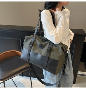 Olive green large capacity travel bag with leather accents and adjustable shoulder strap