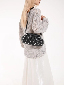 Elegante borsa a tracolla nera con borchie argentate indossata da una modella