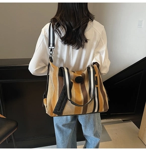 Detail of striped canvas gym tote bag with woven shoulder strap and round logo